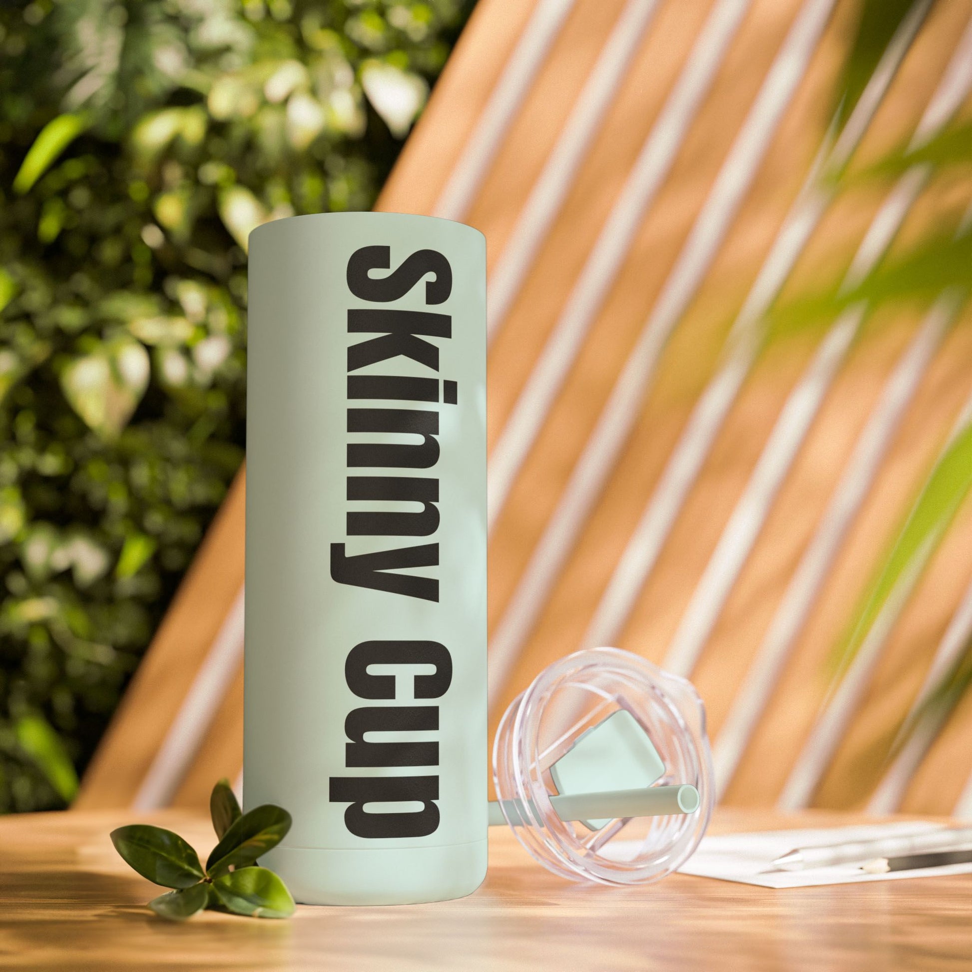 Sleek 20oz insulated light green tumbler with a matte finish, screw-on lid, and matching straw against a colorful background. Keeps drinks cold for 24 hours and hot for 12.